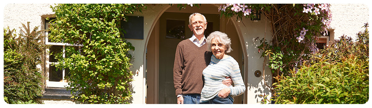 Couple standing in the doorway of their home