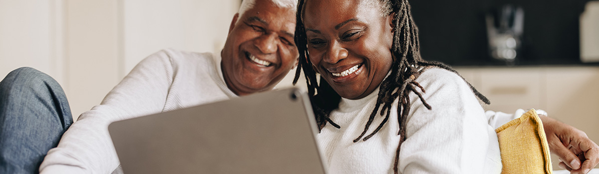 Laughing couple making call on tablet