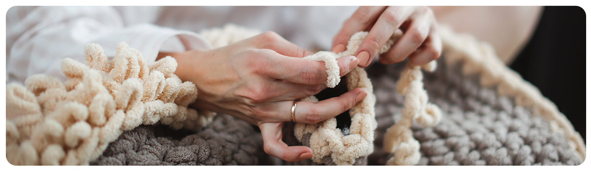 Woman finger knitting a blanket