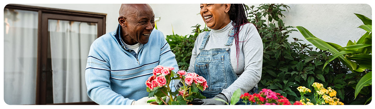 Couple planting pots of flowers