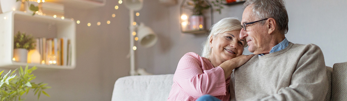 Smiling older couple on sofa