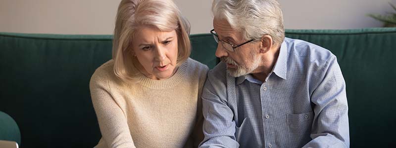 Couple looking at their bills, concern on their faces